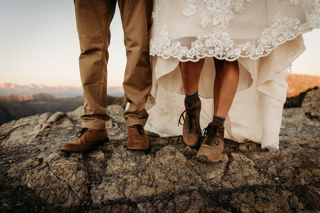 Couple showing off hiking shoes for adventure elopement in the mountains