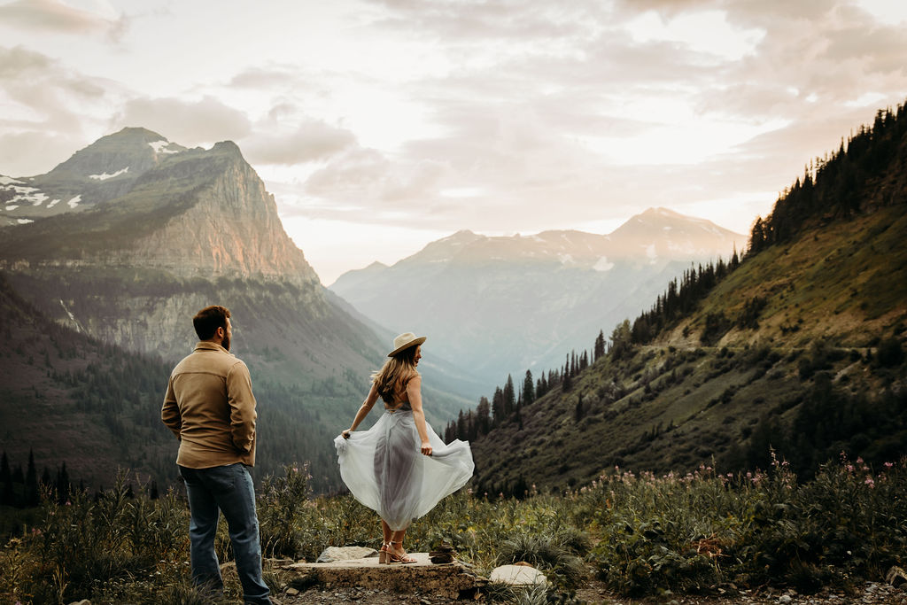 Couple posing for adventurous mountain engagement photos in Glacier National Park