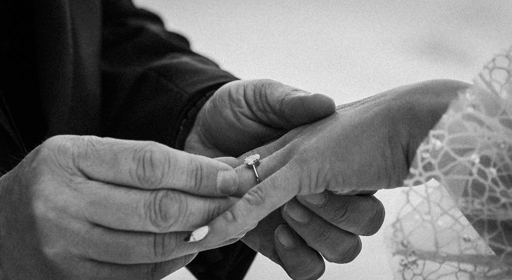 Man putting ring on womens finger during elopement