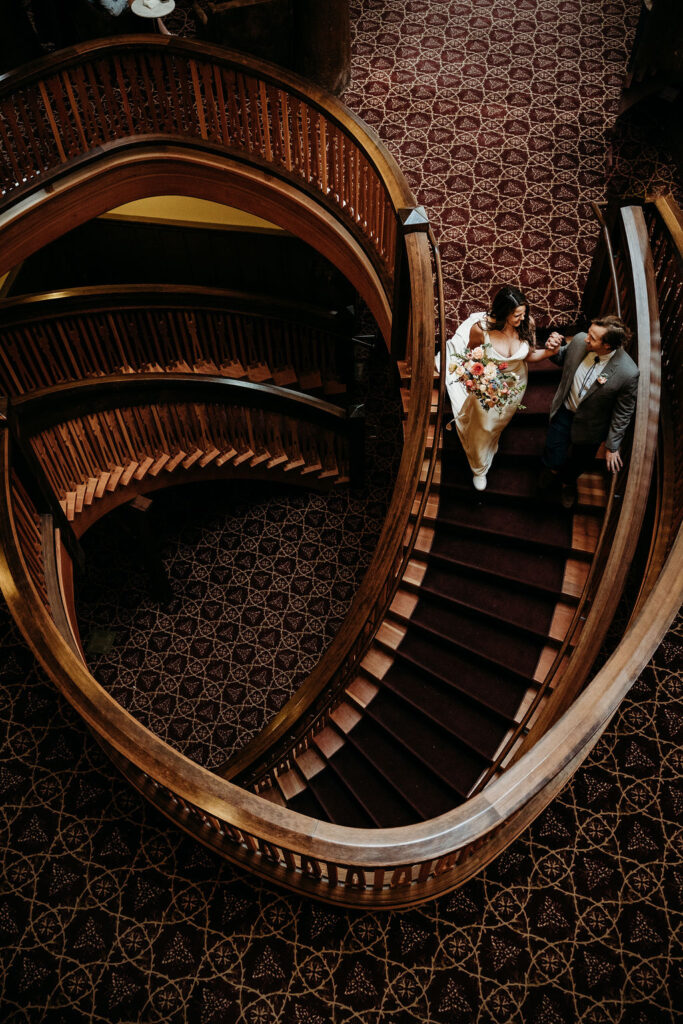 Elopement Photography Inspiration in The Mountains of Glacier National Park | Bride and groom on a staircase at Many Glacier Hotel