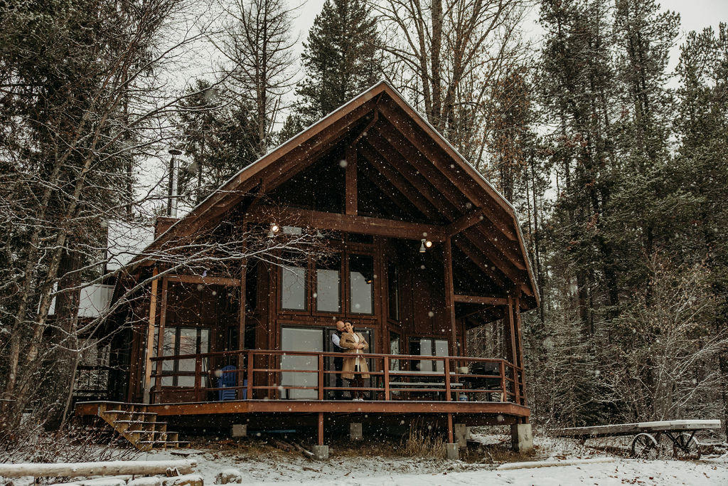 Couple holding each other on a cabin porch