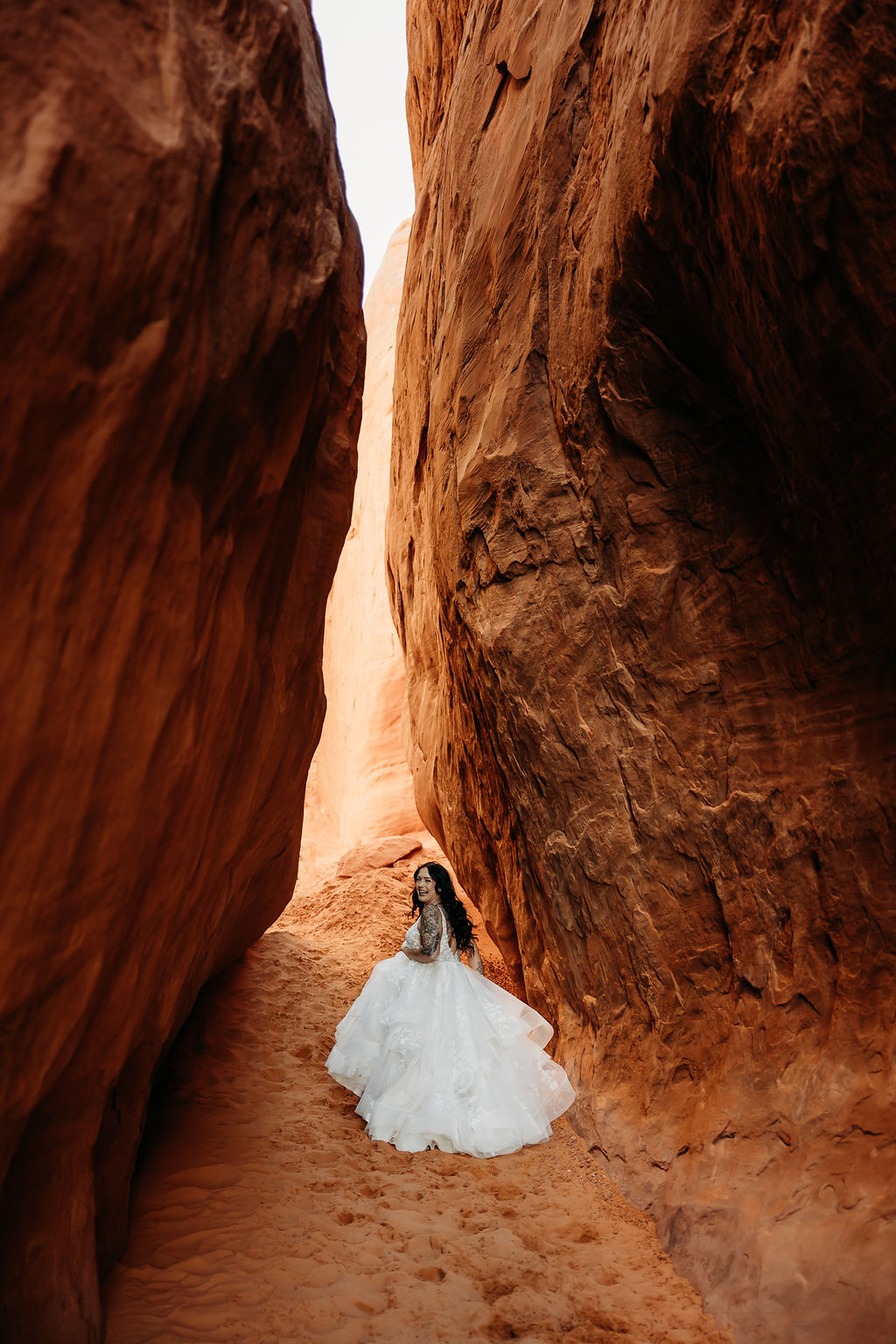 A bride and a narrow canyon at Arches National Park | PHOTOGRAPHY BY BROGAN |  5 REASONS TO HAVE A MOAB NATIONAL PARK ELOPEMENT 