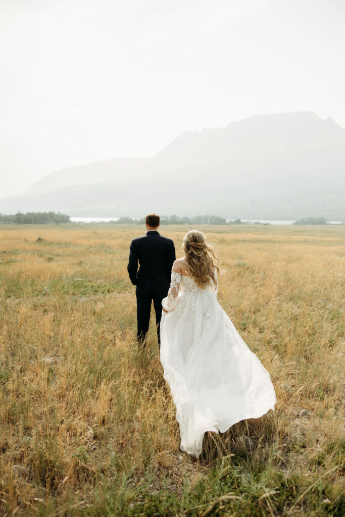 bride and groom taking elopement photos at going to the sun road
