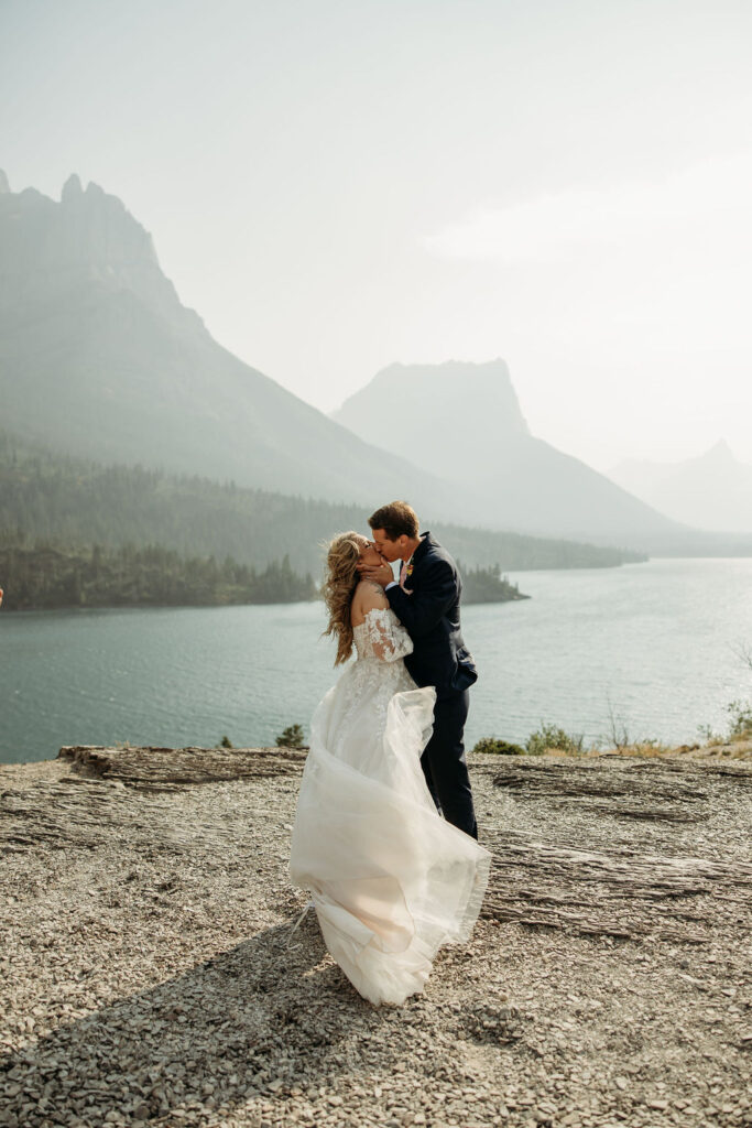 bride and groom taking photos at going to the sun road
