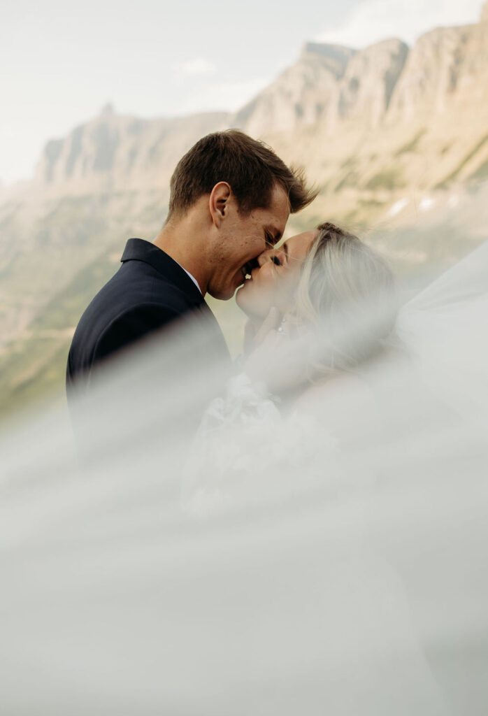 bride and groom taking elopement photos at going to the sun road
