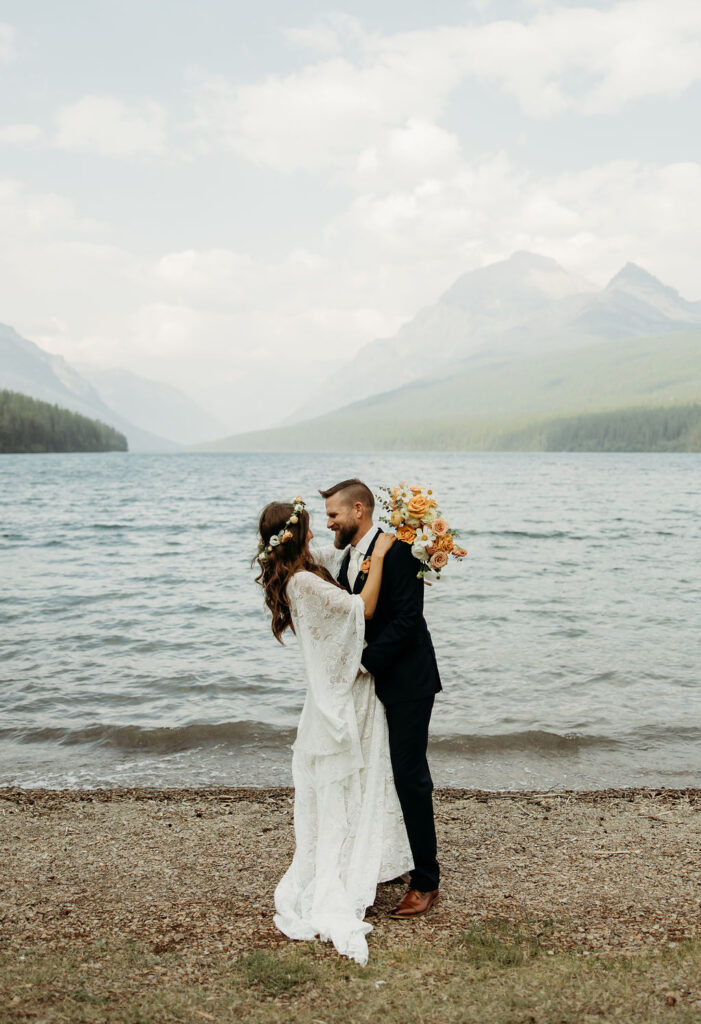 couple taking elopement photos at bowman lake
