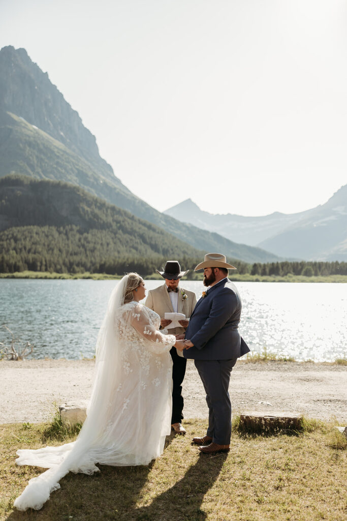 Newlyweds laughing together with the mountains in the background.
