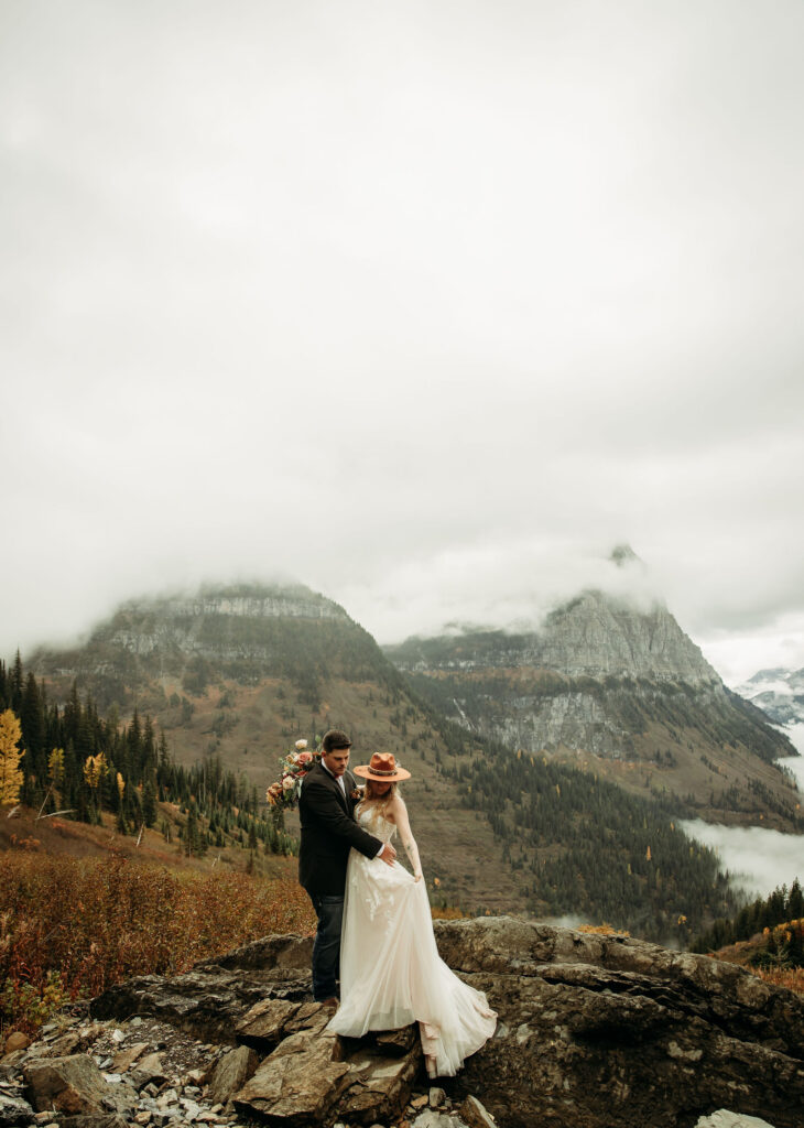 Two lovebirds embracing the adventure of their elopement, posing in the scenic surroundings of Glacier National Park, Montana.