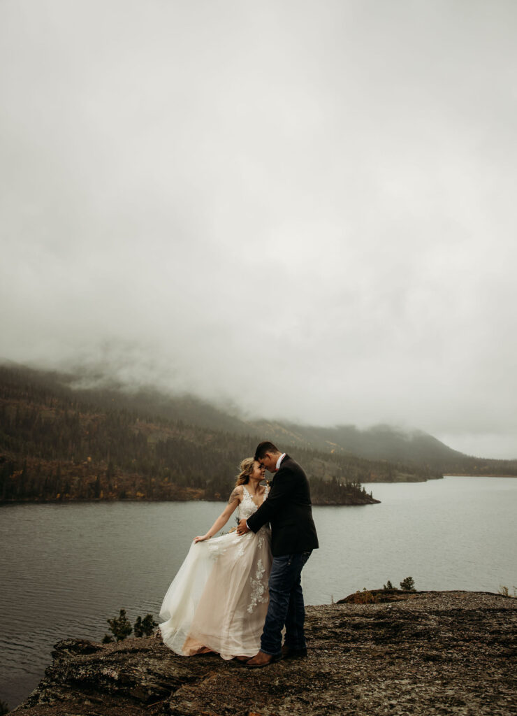 A couple standing together during their adventurous elopement photoshoot in Glacier National Park, Montana, surrounded by stunning natural scenery.
