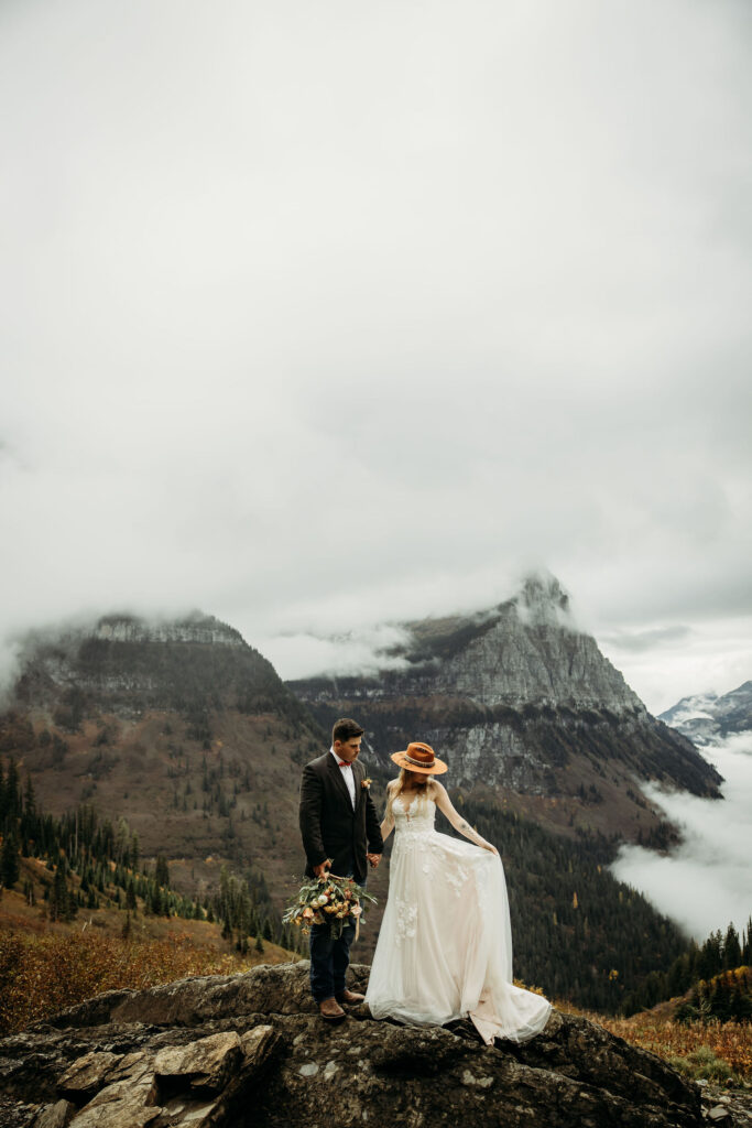 Two lovebirds embracing the adventure of their elopement, posing in the scenic surroundings of Glacier National Park, Montana.
