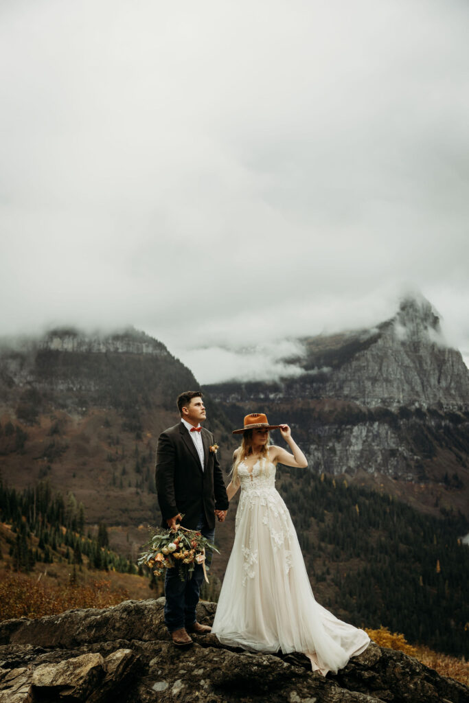 Two lovebirds embracing the adventure of their elopement, posing in the scenic surroundings of Glacier National Park, Montana.