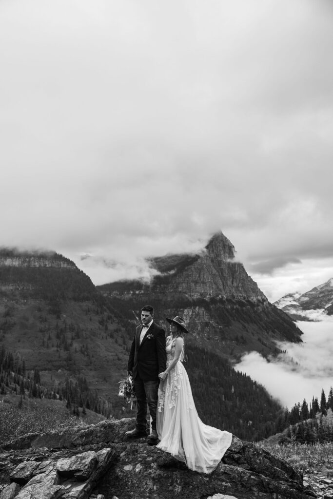 Two lovebirds embracing the adventure of their elopement, posing in the scenic surroundings of Glacier National Park, Montana.