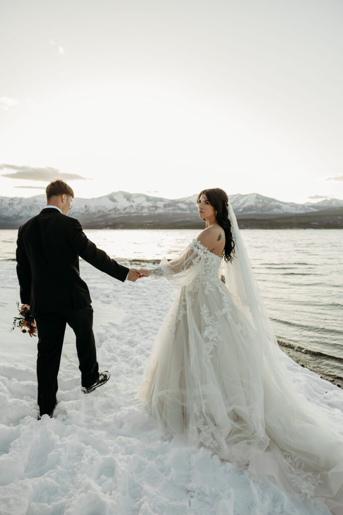 A couple standing together in Glacier National Park, surrounded by stunning mountain views during their adventure elopement.