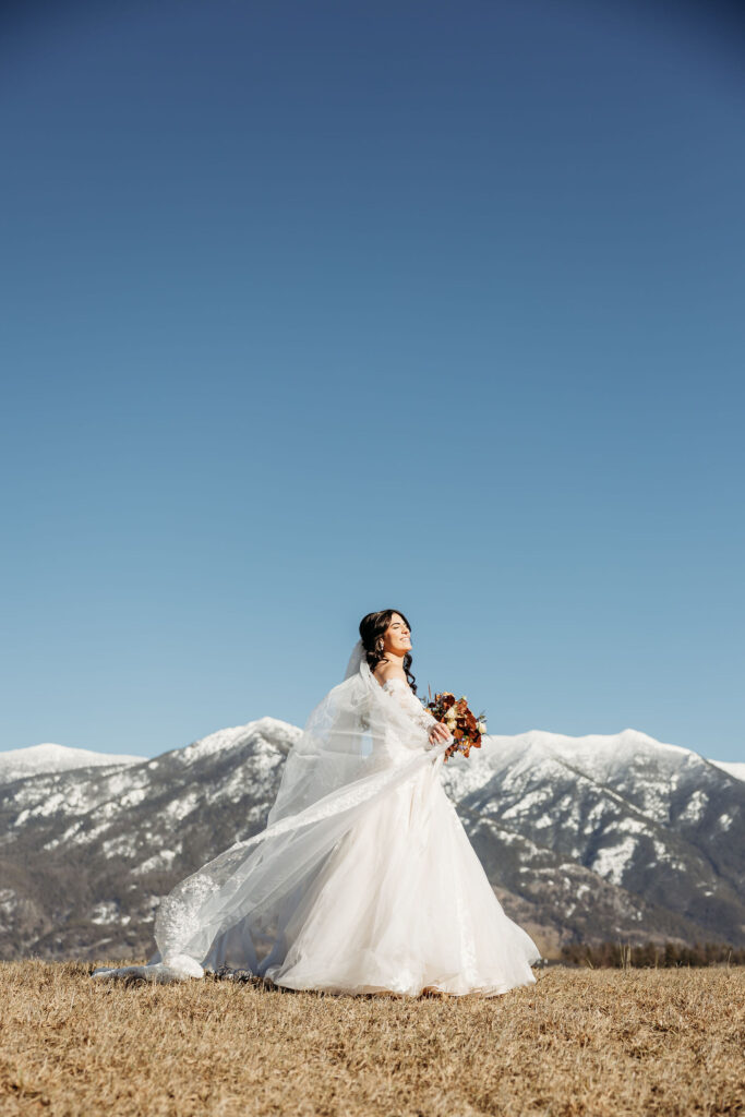 An adventurous pair posing for their elopement photos amidst the breathtaking landscapes of Glacier National Park in Montana.