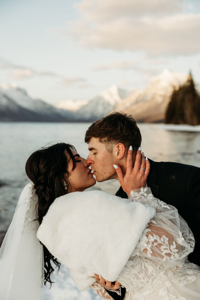 A couple standing together in Glacier National Park, surrounded by stunning mountain views during their adventure elopement.
