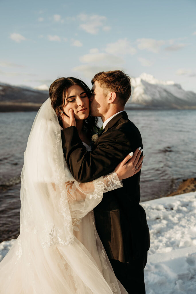 A romantic moment captured as a couple celebrates their elopement in Glacier National Park's rugged beauty.
