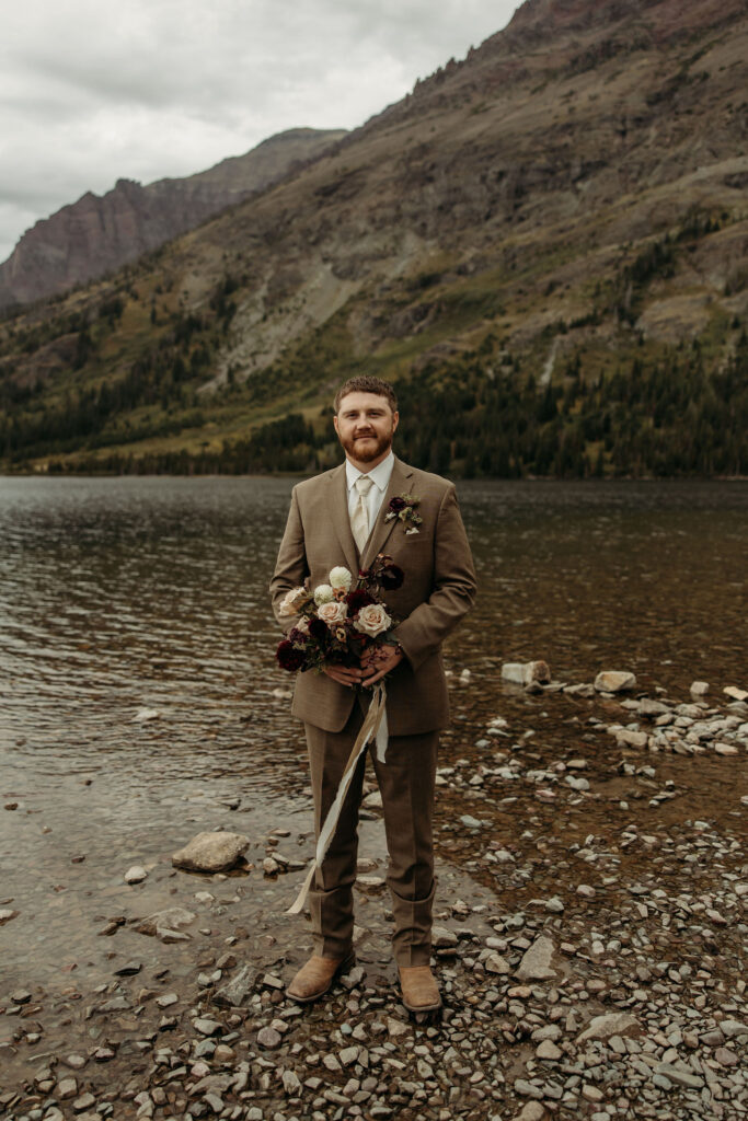 A romantic moment captured as a couple celebrates their elopement in Glacier National Park's rugged beauty.