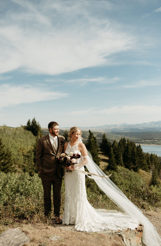 An adventurous couple posing in Glacier National Park, with breathtaking scenery all around.
