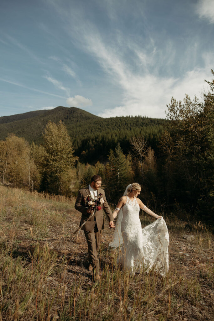 A couple standing together in Glacier National Park, surrounded by stunning mountain views during their adventure elopement.