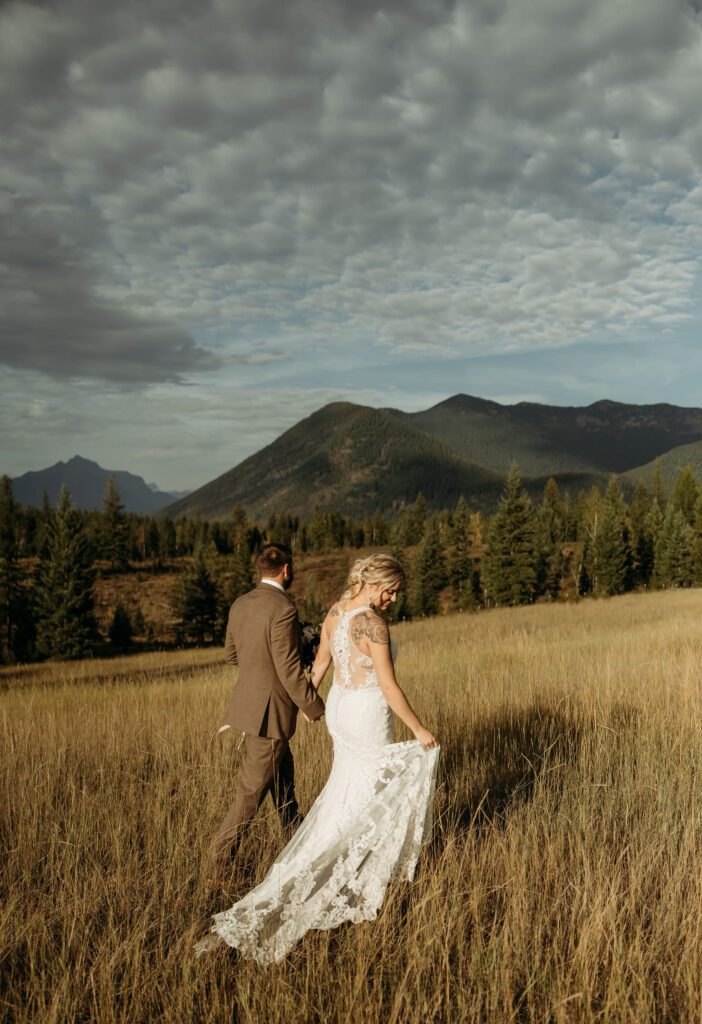 A couple standing together in Glacier National Park, surrounded by stunning mountain views during their adventure elopement.
