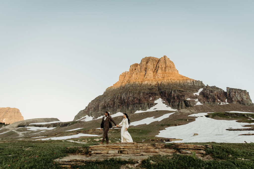 A couple standing together during their adventurous elopement photoshoot in Glacier National Park, Montana, surrounded by stunning natural scenery.