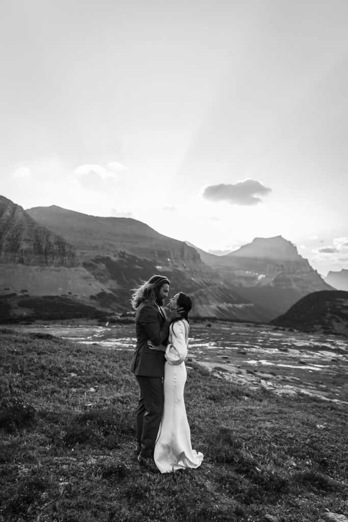 An adventurous pair posing for their elopement photos amidst the breathtaking landscapes of Glacier National Park in Montana.
