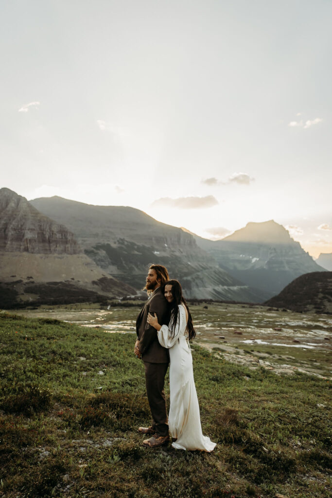 A couple standing together during their adventurous elopement photoshoot in Glacier National Park, Montana, surrounded by stunning natural scenery.
