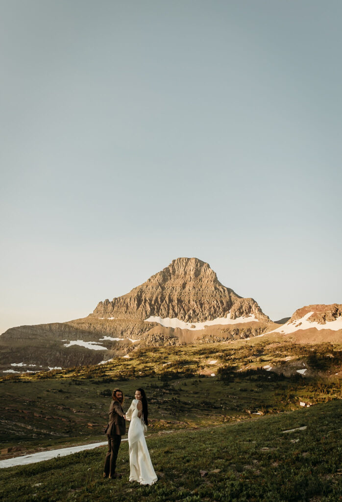 A couple capturing their elopement memories in Glacier National Park, Montana, with a backdrop of rugged beauty and wide-open spaces.
