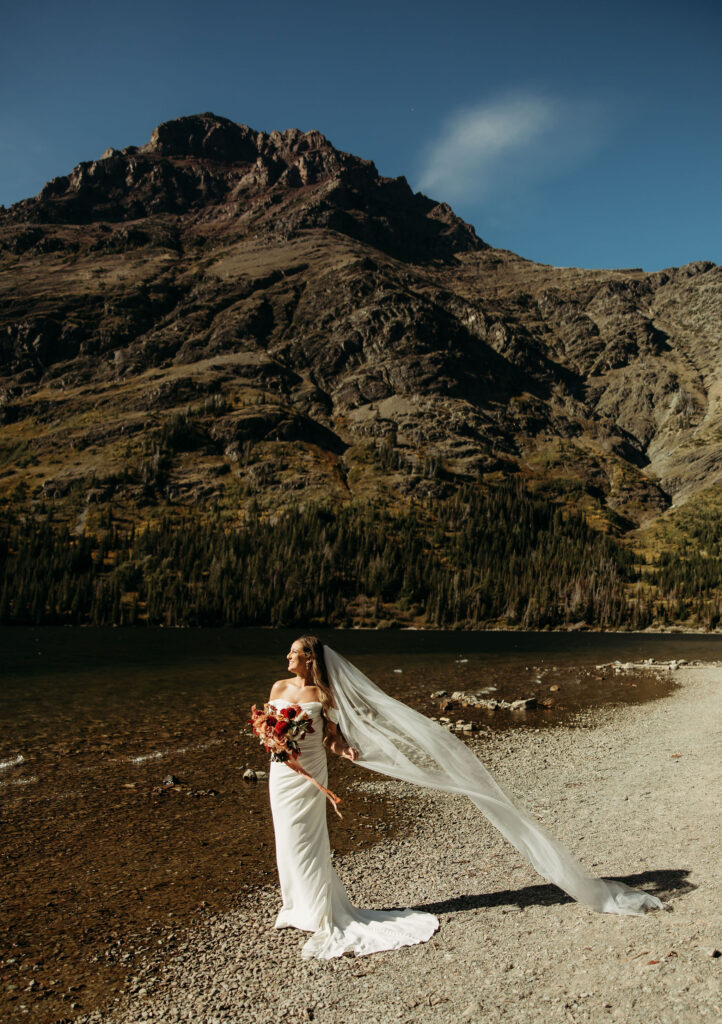 An adventurous couple posing in the scenic landscape of Glacier National Park for their elopement session.
