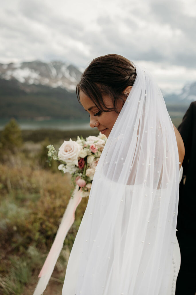 An adventurous couple posing in the scenic landscape of Glacier National Park for their elopement session.
