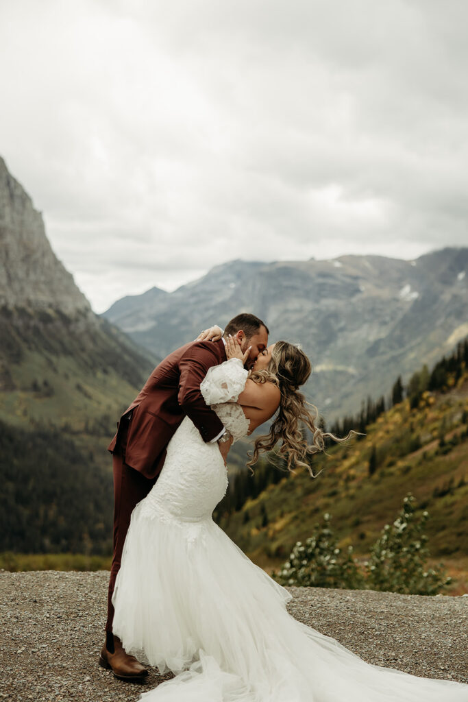 A couple embracing in Glacier National Park, celebrating their destination elopement with stunning mountain views.
