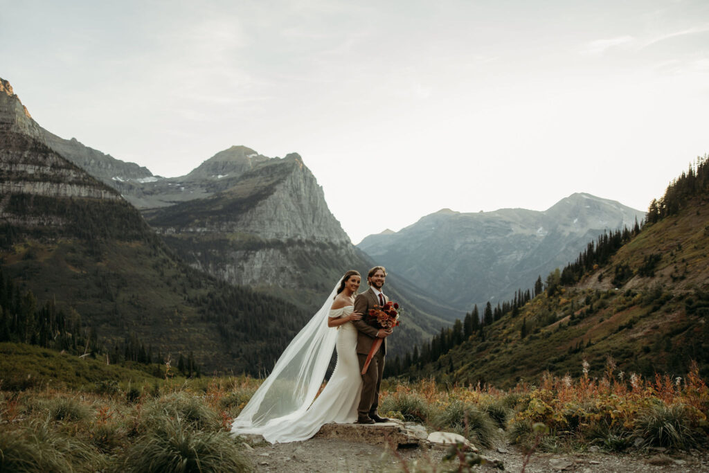 A couple standing together in Glacier National Park, capturing their adventurous destination elopement.