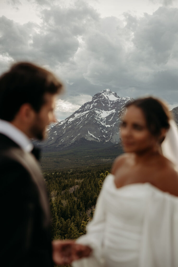 A couple standing together in Glacier National Park, capturing their adventurous destination elopement.
