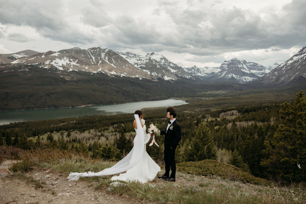 A couple standing together in Glacier National Park, capturing their adventurous destination elopement.
