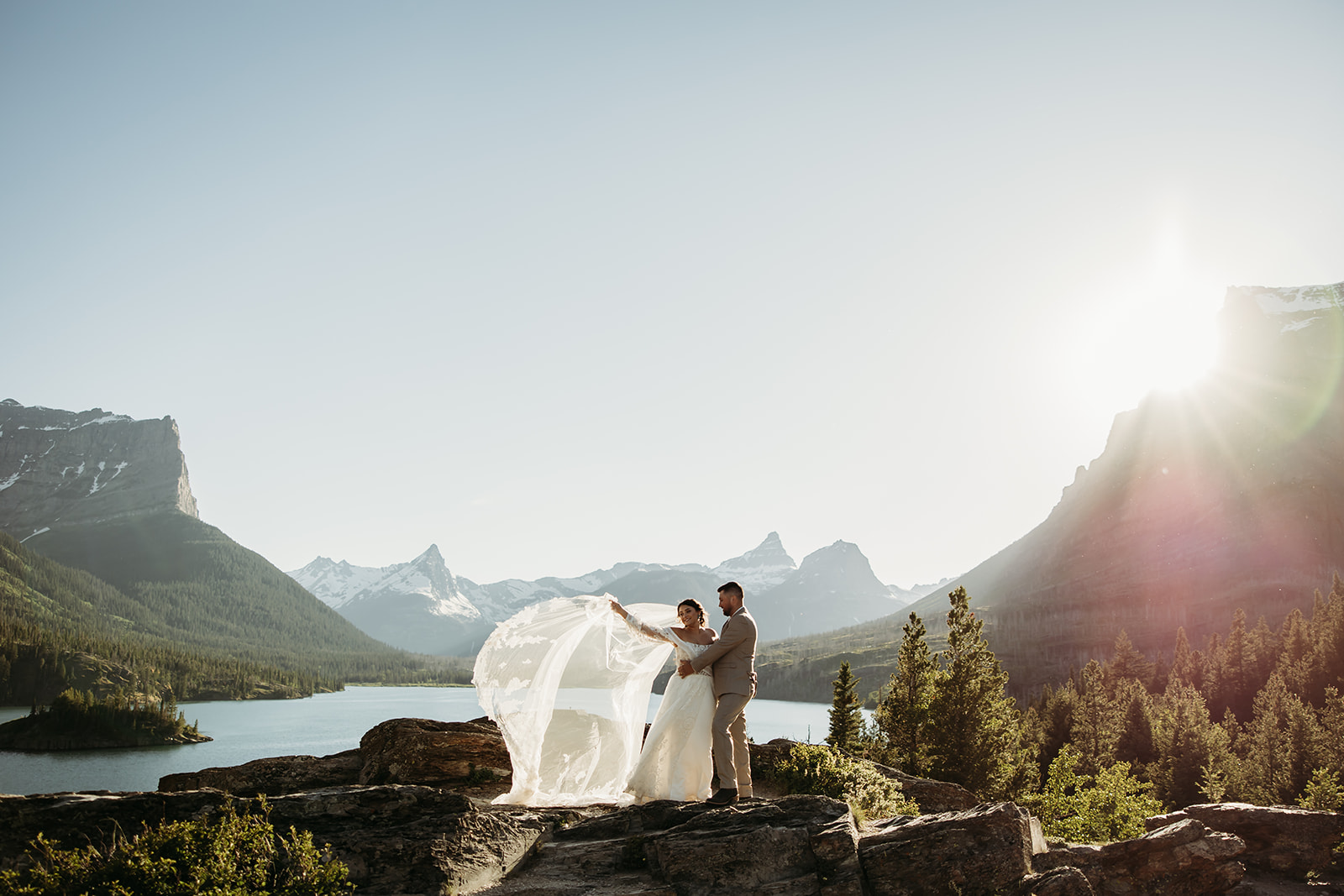 a couple sharing a quiet moment by a glacier lake during their adventure elopement in Glacier National Park