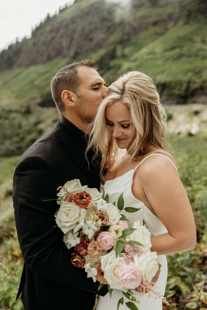 Bride and groom sharing a kiss with mountain views in Montana
