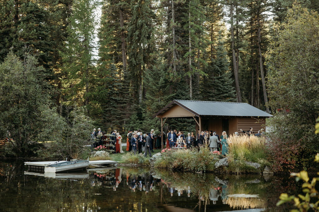 A rustic montana wedding reception outdoors on a lake.