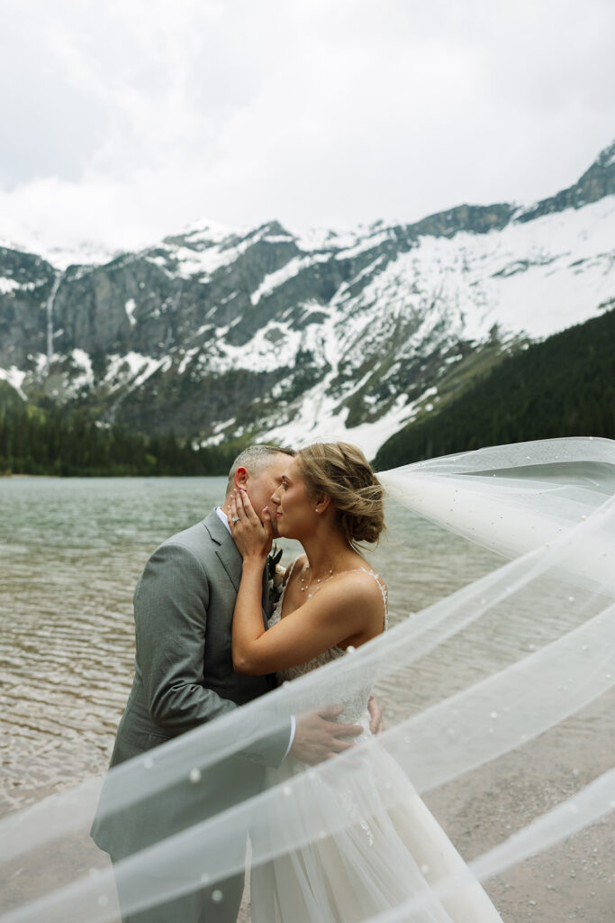 Couple sharing a candid moment during their adventure elopement in Glacier National Park
