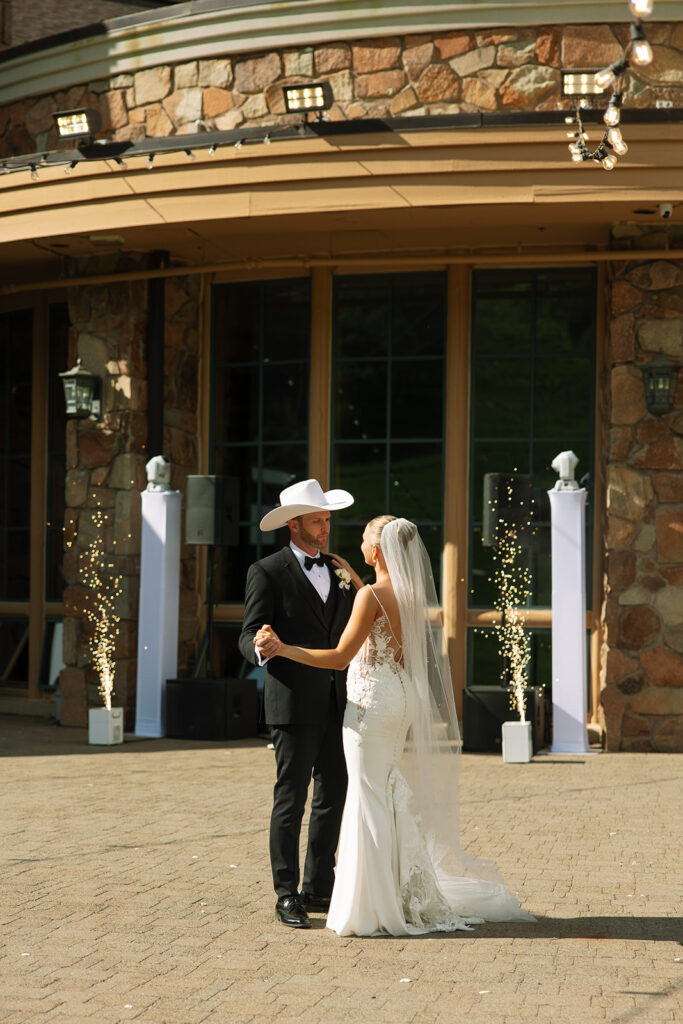 A couple celebrating their luxury western wedding with mountain views in the background.
