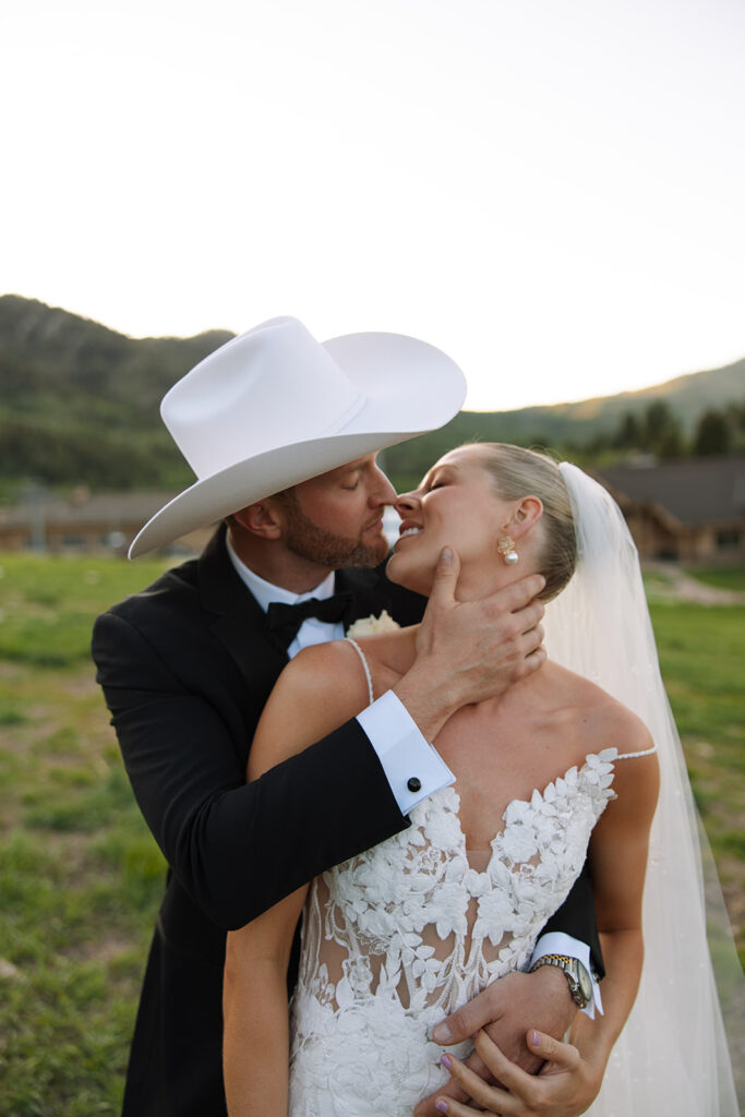 Bride and groom sharing a candid moment during their upscale western wedding celebration.
