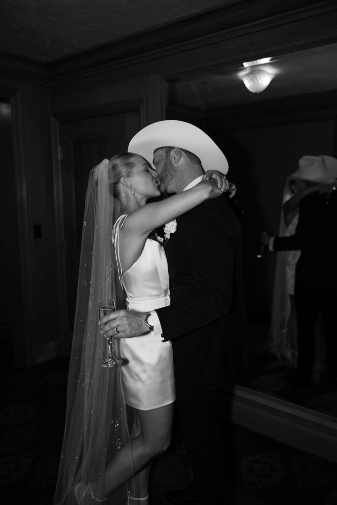Bride and groom sharing a candid moment during their upscale western wedding celebration.
