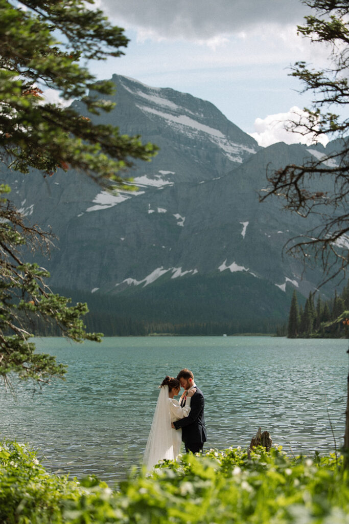 Couple walking through wildflowers at Many Glacier in Glacier National Park.
