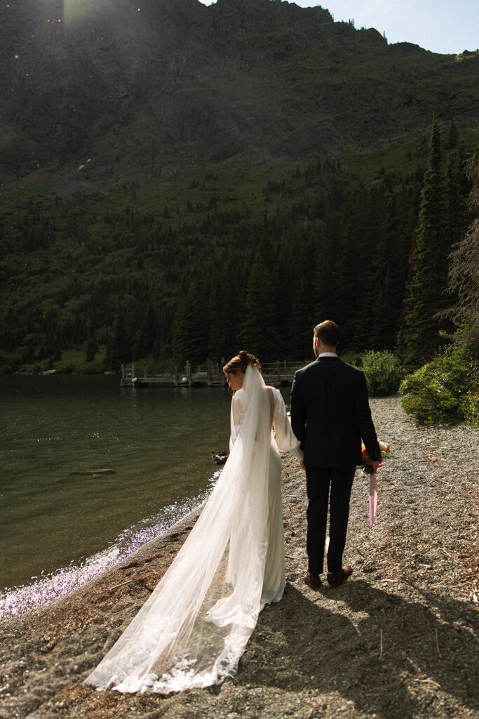 Couple walking through wildflowers at Many Glacier in Glacier National Park.
