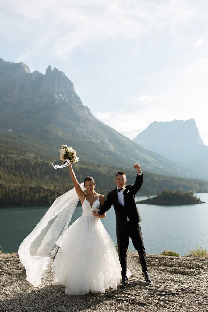 Bride and groom holding hands during their Sun Point ceremony in Glacier National Park
