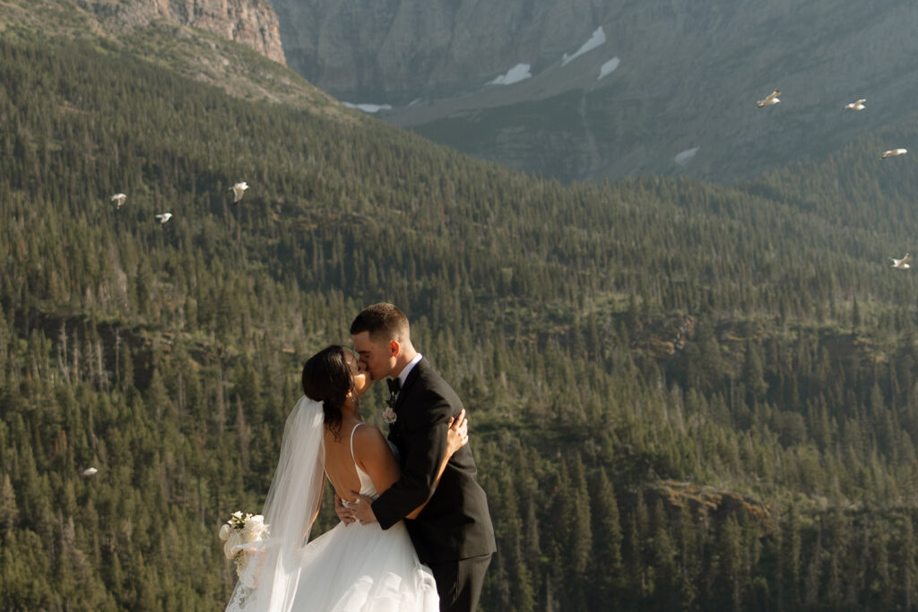 Bride and groom holding hands during their Sun Point ceremony in Glacier National Park
