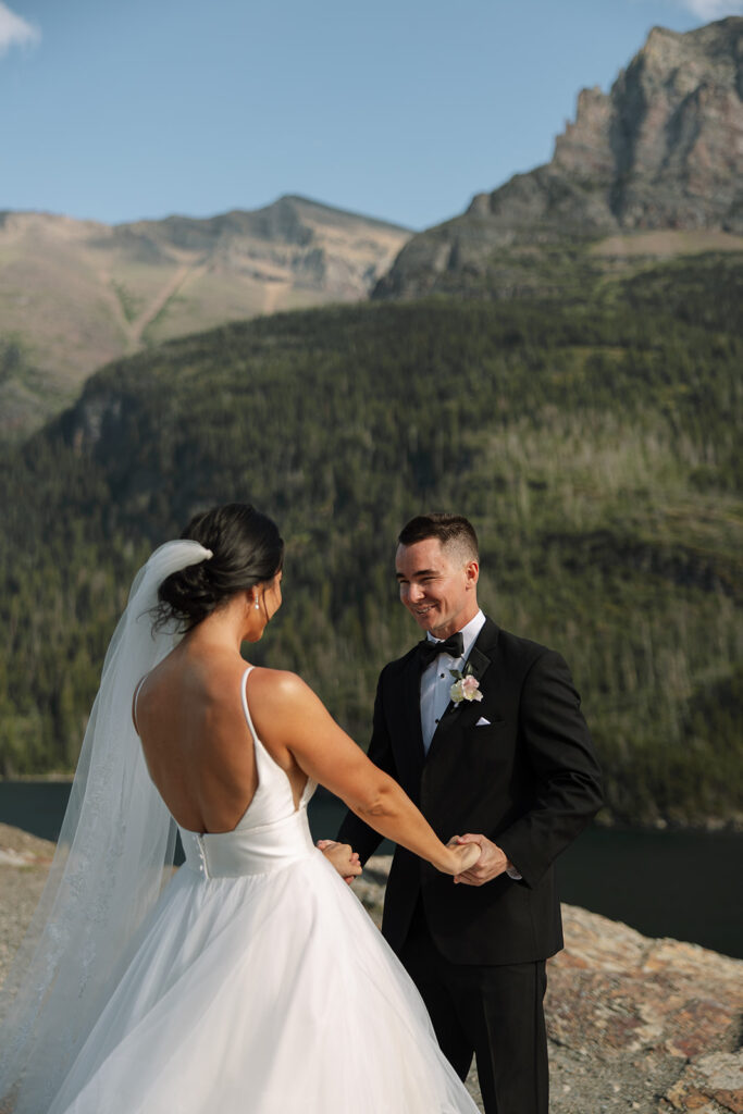 Bride and groom holding hands during their Sun Point ceremony in Glacier National Park

