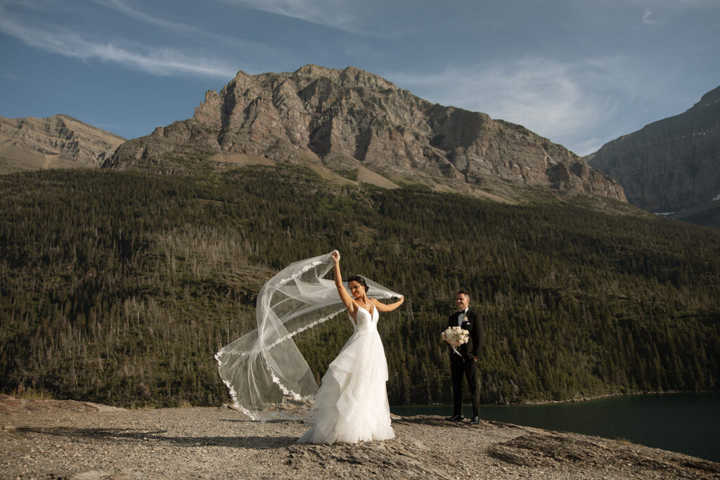 Bride and groom holding hands during their Sun Point ceremony in Glacier National Park
