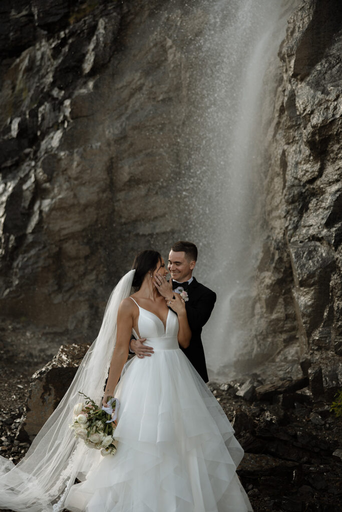 Newlyweds walking along a scenic overlook on Going to the Sun Road
