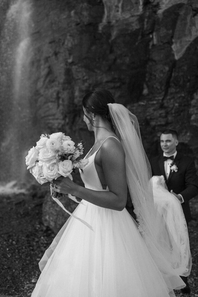Newlyweds walking along a scenic overlook on Going to the Sun Road
