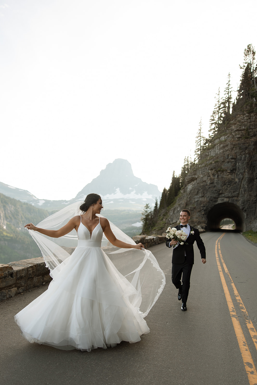 Couple standing together along Going to the Sun Road with mountains in the background